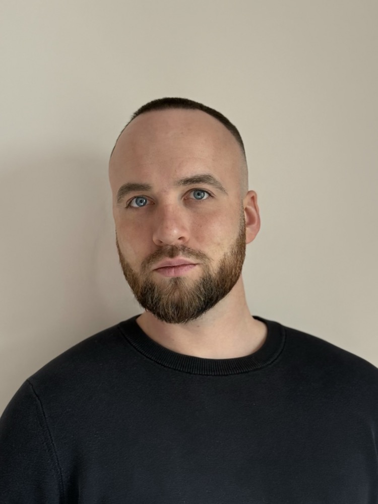 Daniel — English teacher, beard, blue eyes, dark crew-neck
